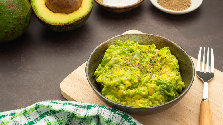 Guacamole in bowl on cutting board