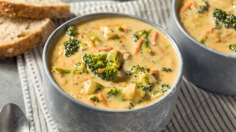 broccoli and cheddar soup in a serving bowl with bread