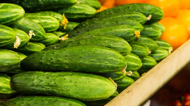A stack of cucumbers at a grocery store