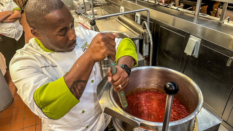 Chef Tookes whisking marinara sauce