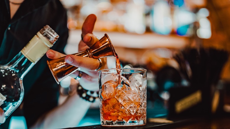 Mixologist making Negroni cocktail