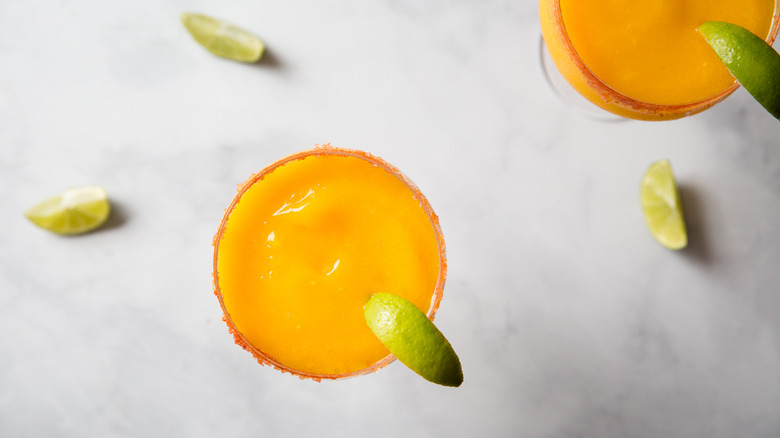 Frozen mango margaritas on table
