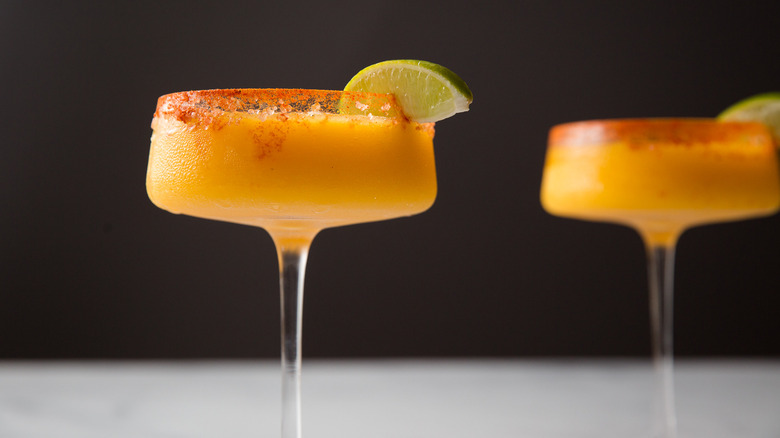 Frozen mango margaritas on table