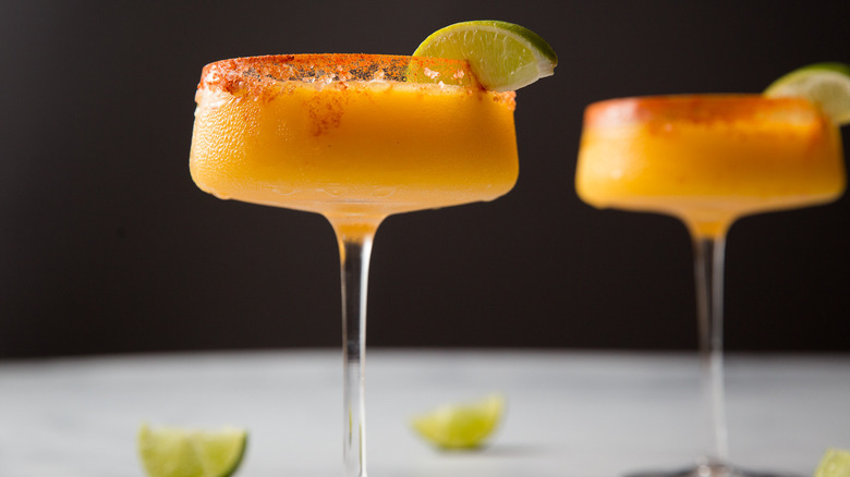 Frozen mango margaritas on table