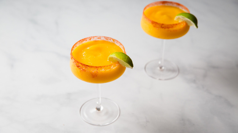 Frozen mango margaritas on table