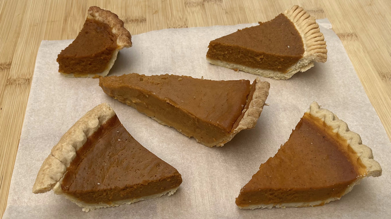 Pumpkin pie slices on wooden board