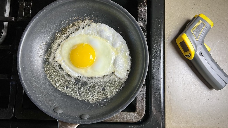 An egg frying in butter in a nonstick pan