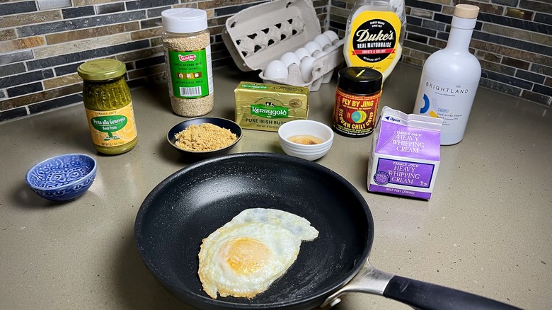 A fried egg surrounded by a variety of cooking oils and toppings