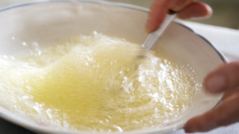 Hands whipping egg whites in a bowl