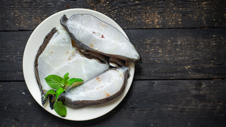 catfish steaks on white plate with greens