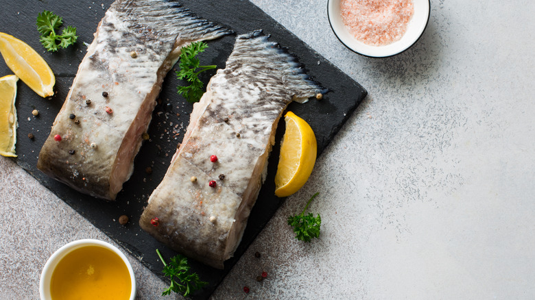 raw catfish steaks on slate with lemon slices 