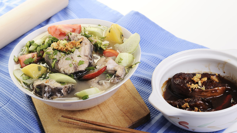 bowl of Canh Chua Cá on blue linen