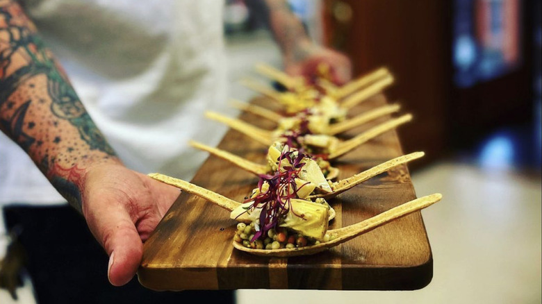 waiter serving edible spoons