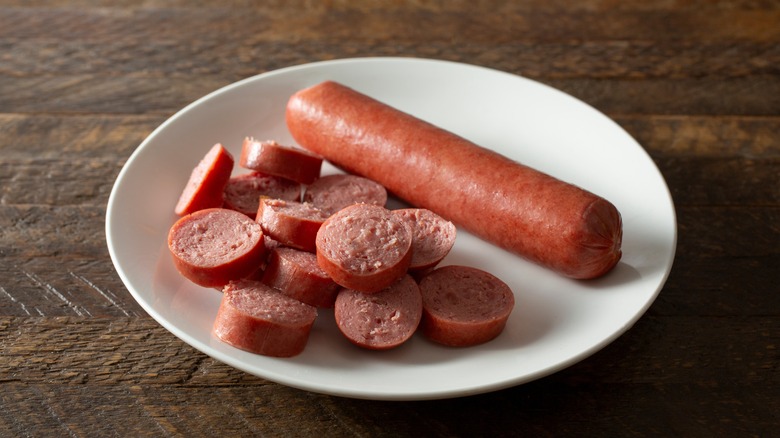 cut up hot dog and whole hot dog on white plate