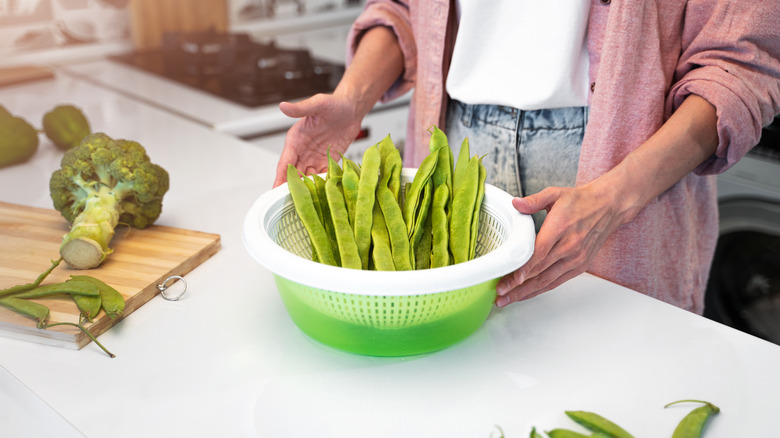 person washing romano beans