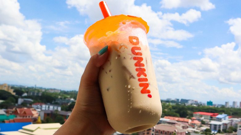 Hand holding Dunkin' iced coffee