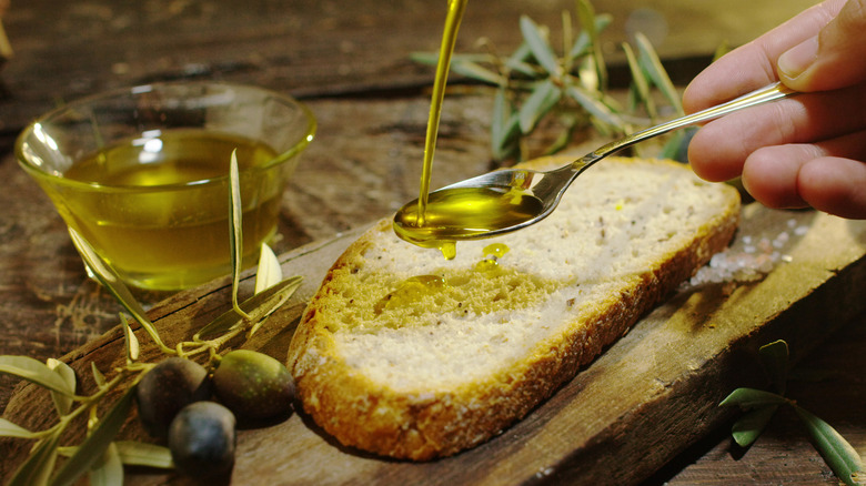 pouring olive oil over bread