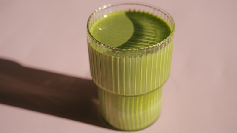 Glass of matcha with a pink background