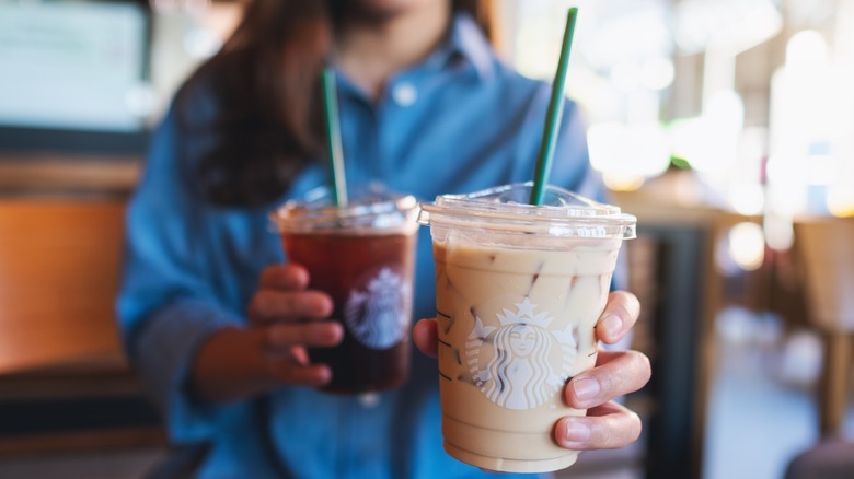 Hands holding Starbucks cups 