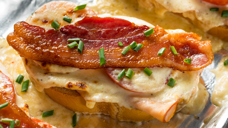 Kentucky hot brown sandwich with tomatoes, bacon and green onions