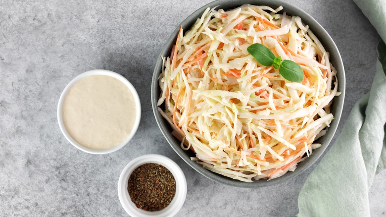 bowls of coleslaw, dressing, and seasoning