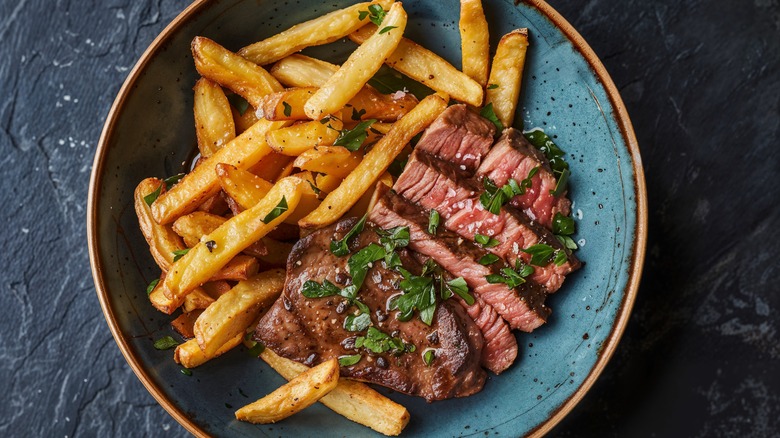 rustic steak frites on blue bowl