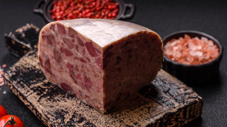 Homemade head cheese surrounded by fruit and vegetables