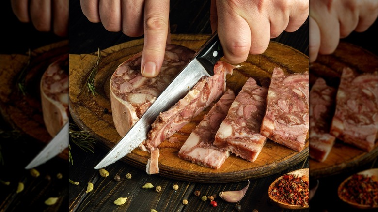 Person slicing head cheese on a cutting board