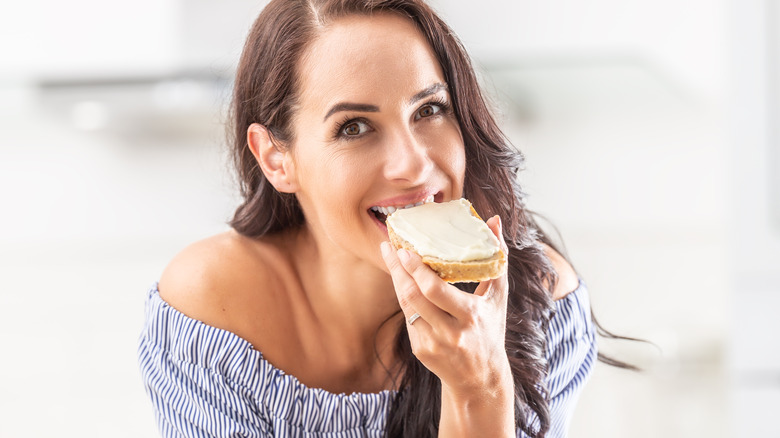 Woman eating toast with margarine spread