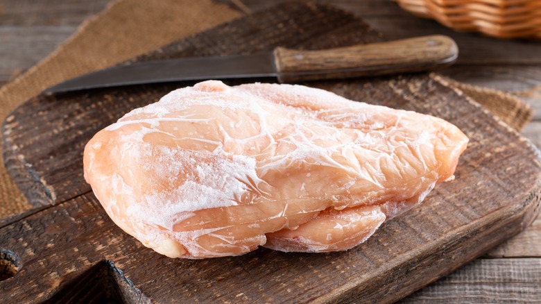 frozen chicken breast on cutting board