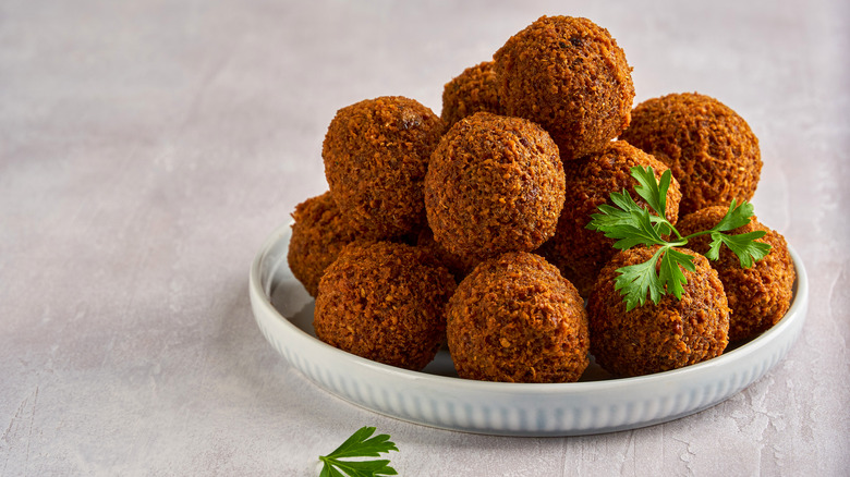 Falafel stacked on a plate with parsley