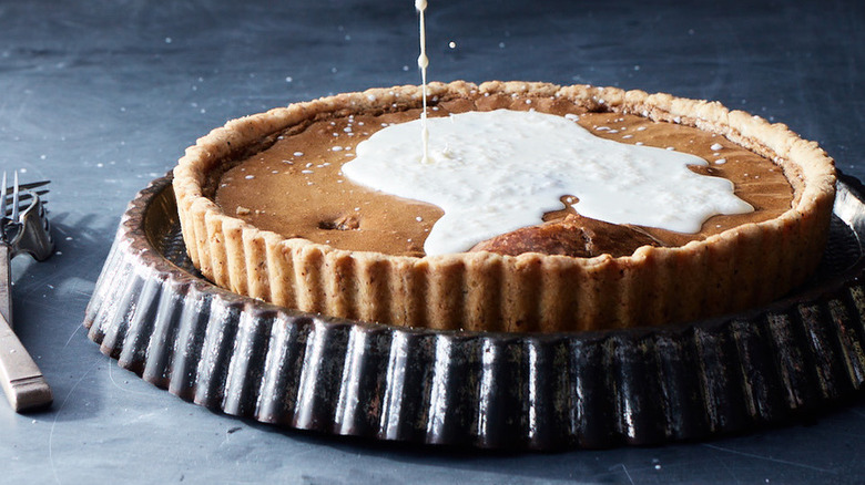 Pouring cream on maple tart