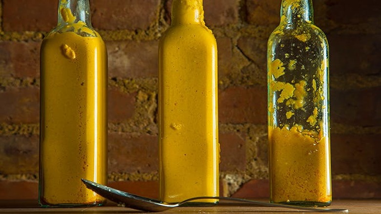 three bottles of yellow hot sauce