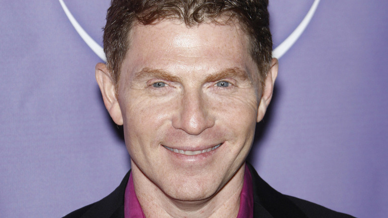 bobby flay smiling in red shirt with black blazer