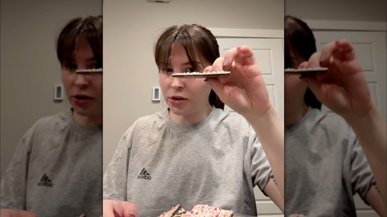 A person holds up a piece of Costco's Peppermint Bark