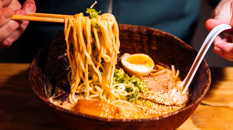 person eating a bowl of ramen