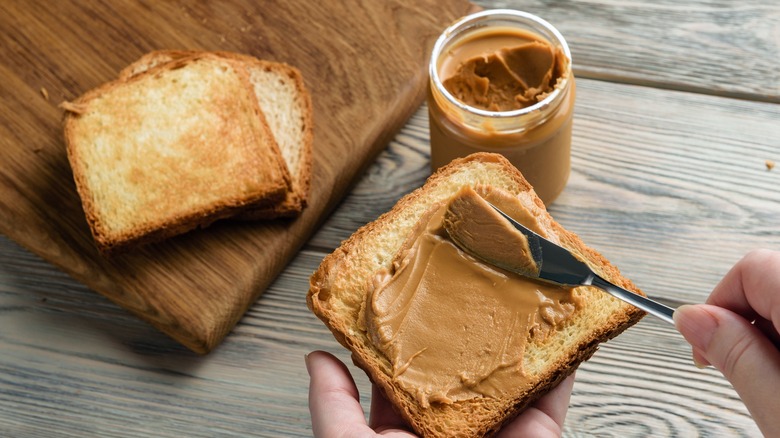 peanut butter being put onto bread