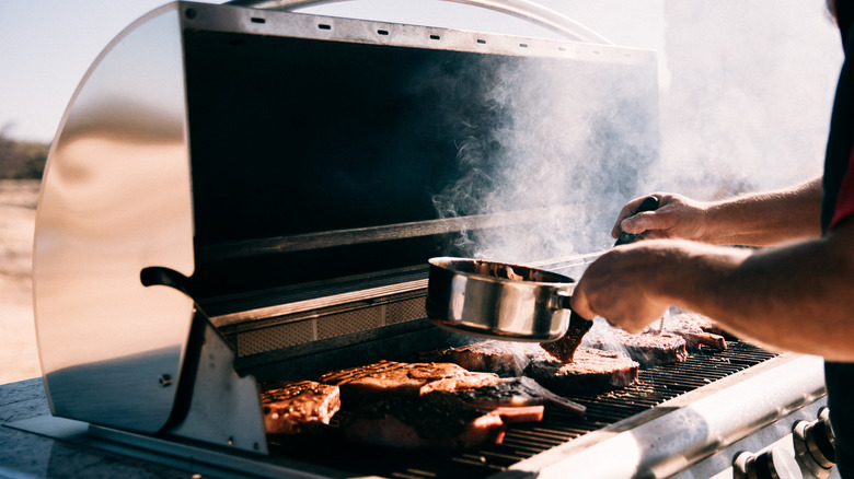 Man adding ingredients to smoker 