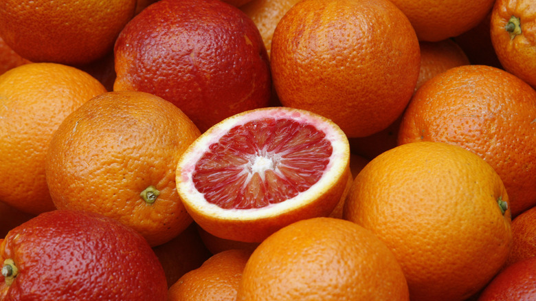 A pile of blood oranges, one sliced