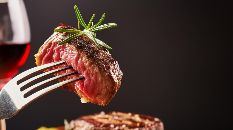 Grilled ribeye with rosemary garnishing.