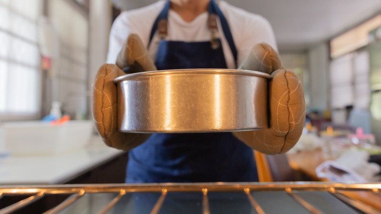 baker taking cake from oven