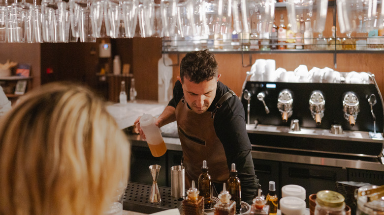 bartender reaches below to speed rail