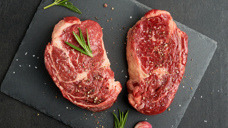 Overview of two steaks on a cooking stone