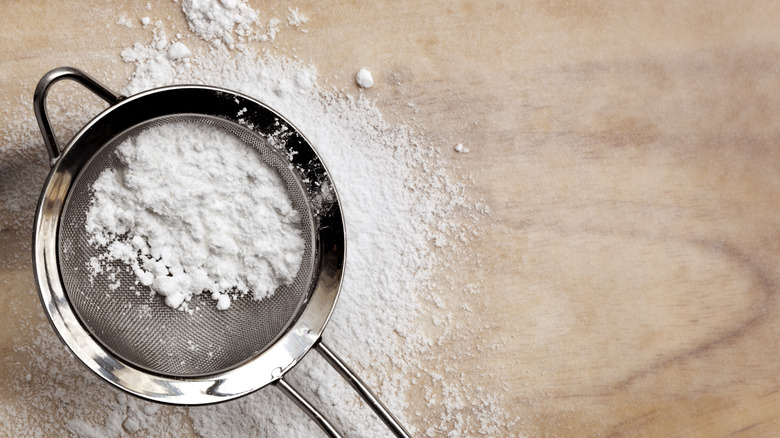 Powdered sugar in sifter wood surface