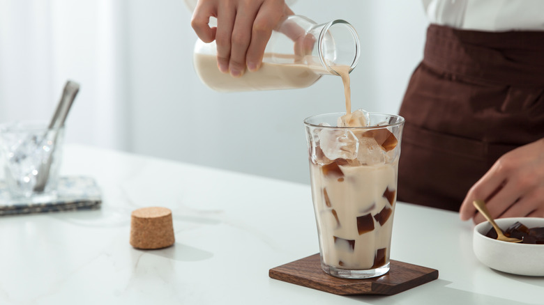 Milk pouring over jellied coffee and ice