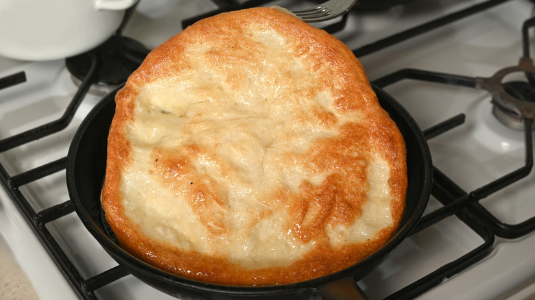 Homemade cowboy bread cooking in a skillet
