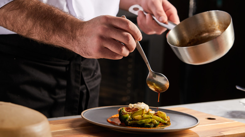 Chef pours a gastrique over food