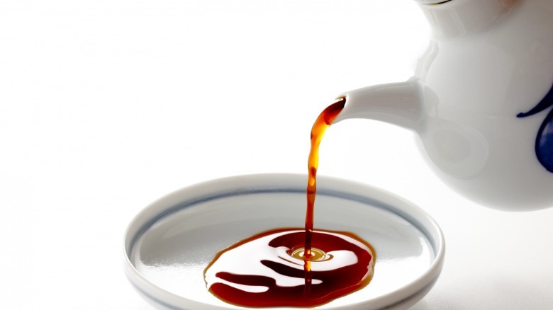 soy sauce being poured into a dish