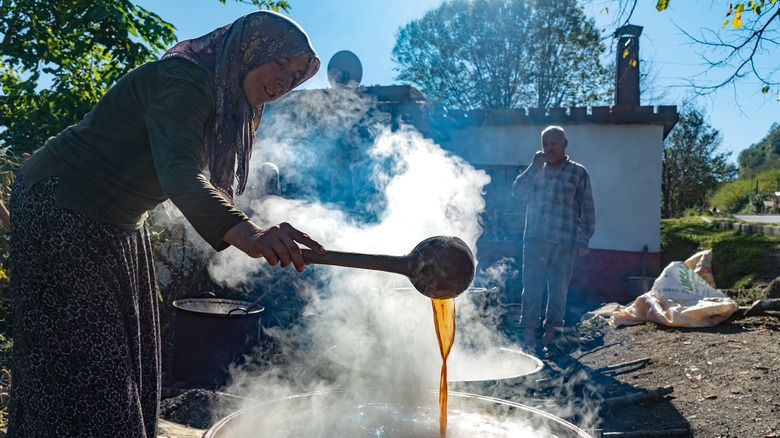 woman producing grape molasses