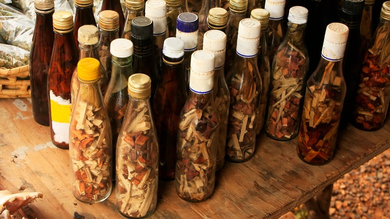 Bottles of steeping mamajuana full of dried ingredients